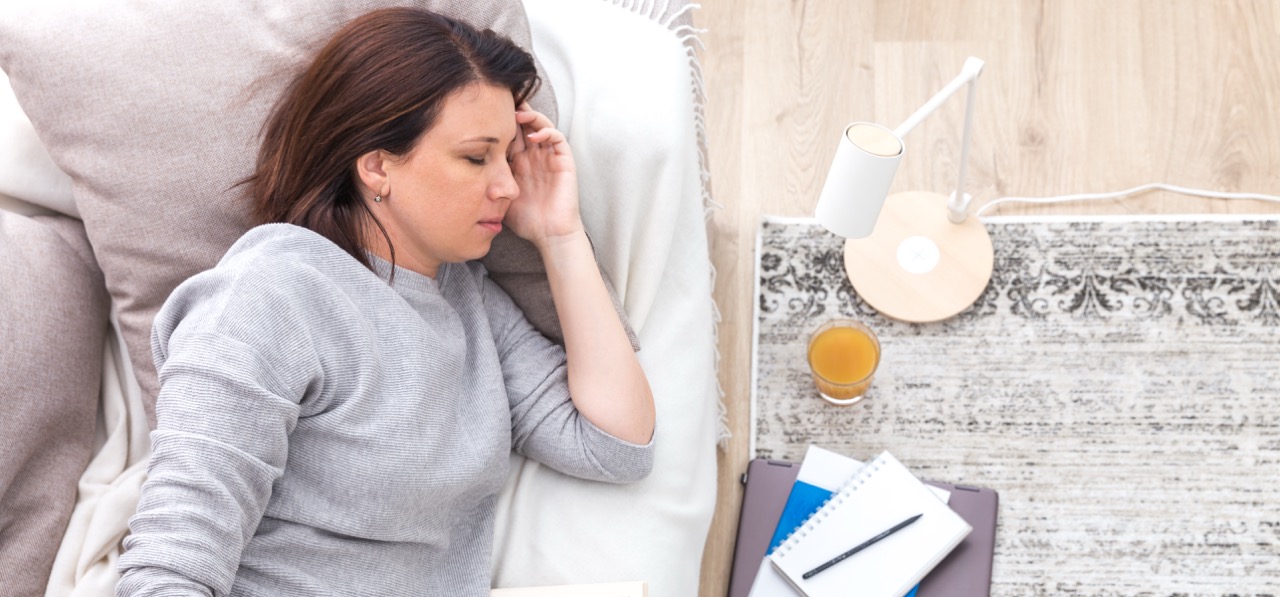 Erschöpfte Frau schläft auf dem Sofa Chronic Fatigue Symptom Symbolbild
