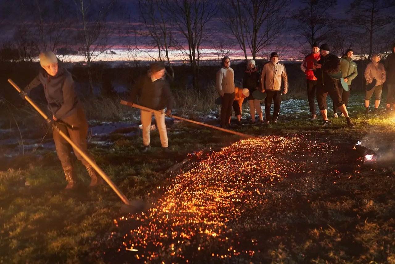 Gruppe geht barfuß über die glühenden Kohlen beim Feuerlauf