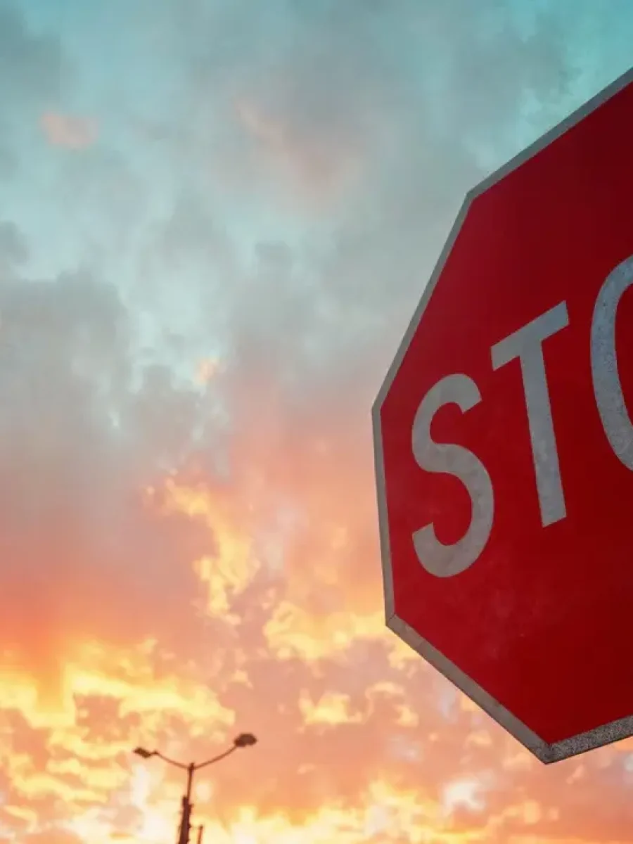 Stoppschild vor dramatischem Abendhimmel